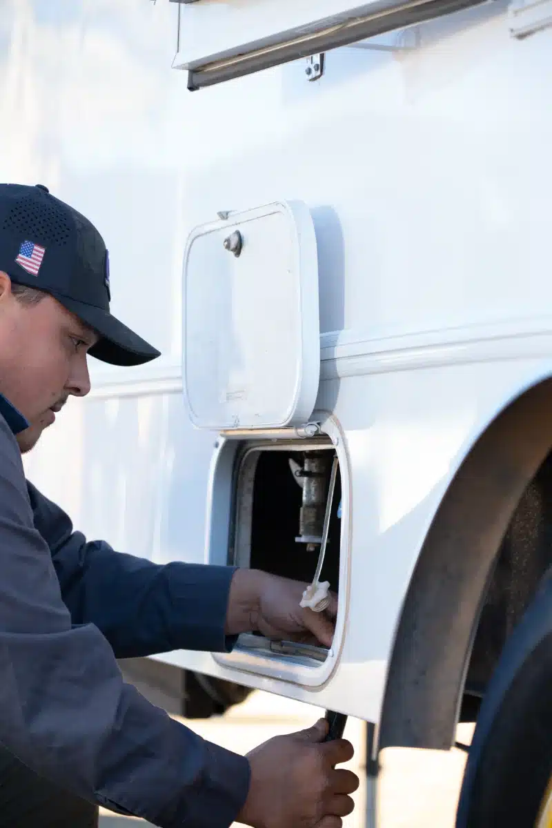 Stamback Services employee hooking a hose up to the VIP Trailer